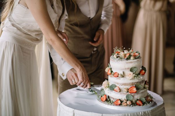 Ein Brautpaar schneidet gemeinsam die Hochzeitstorte an